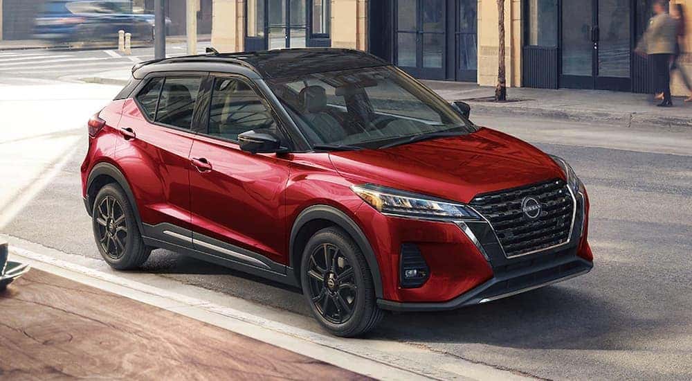 A red 2024 Nissan Kicks SR parked on a city street.