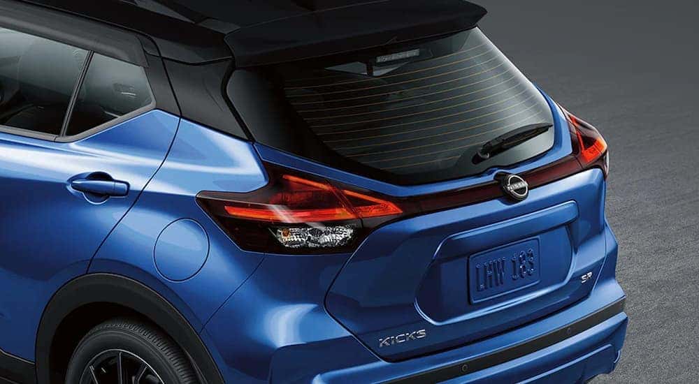 The rear end of a blue 2024 Nissan Kicks SR.