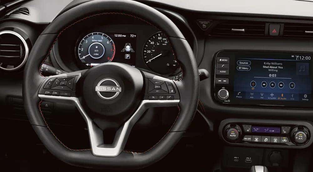 The steering wheel and infotainment screen in a 2024 Nissan Kicks for sale.