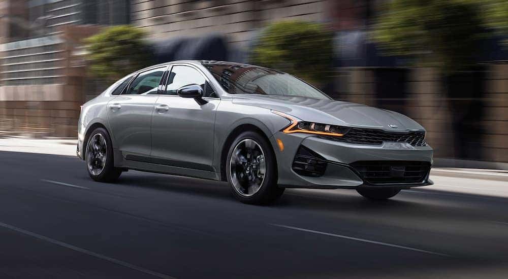 A grey 2021 Kia K5 is shown from the front at an angle.
