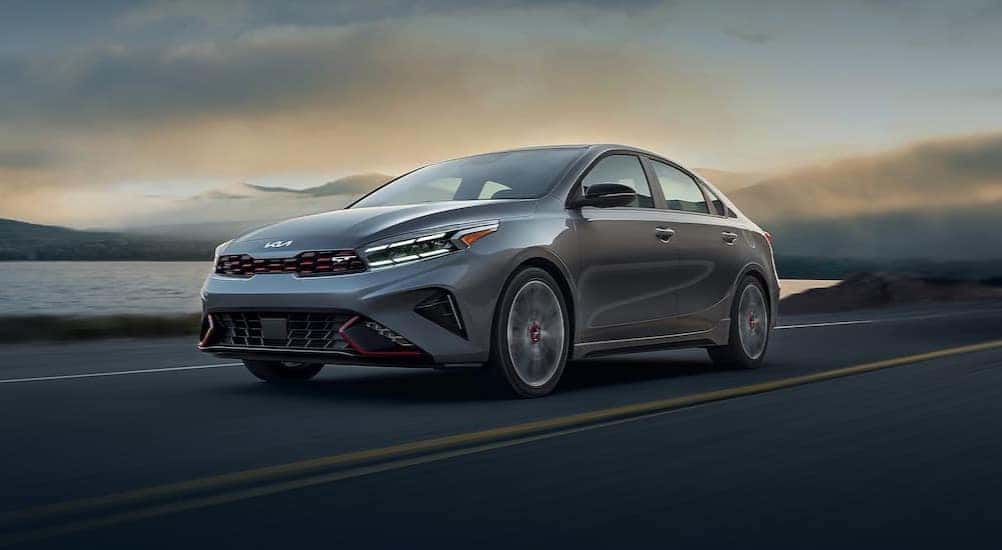 A gray 2024 Kia Forte GT is shown driving on a highway.