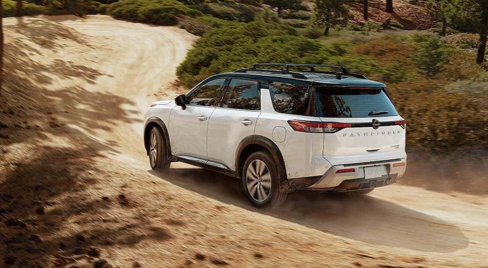 A white 2024 Nissan Pathfinder is shown driving off-road.