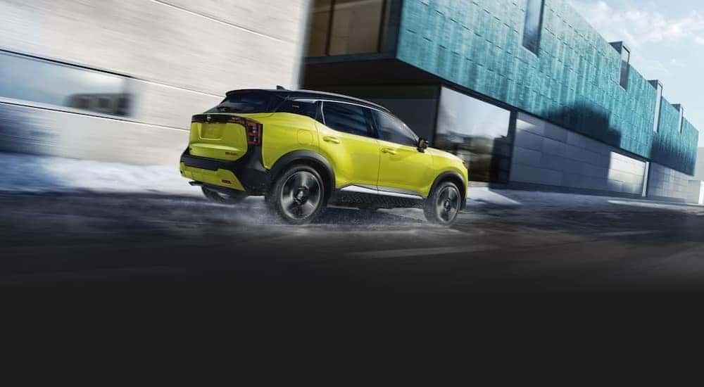 A yellow 2025 Nissan Kicks for sale near Savoy is shown driving.