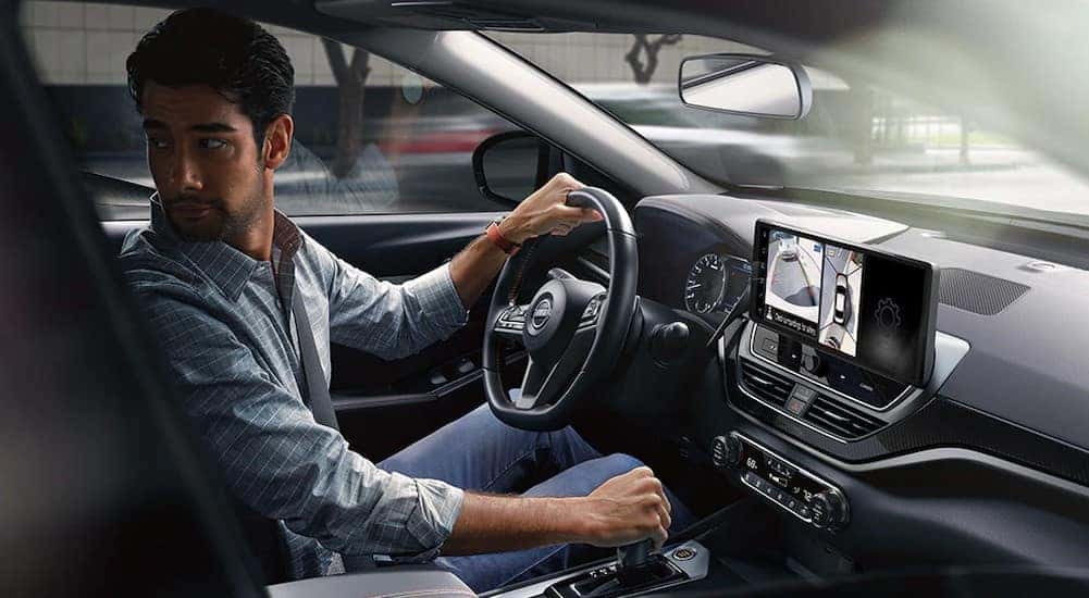 The black interior and dash in a 2024 Nissan Altima for sale is shown.