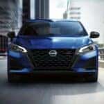 A blue 2024 Nissan Altima SR is shown driving on a city street.