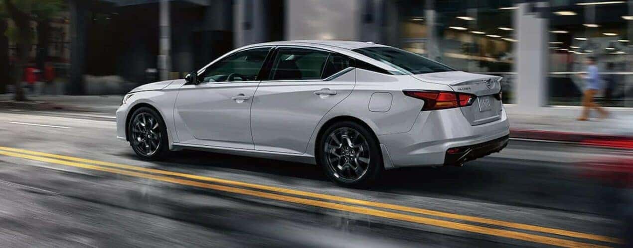 A white 2024 Nissan Altima SR VC-Turbo is shown driving on a city street.