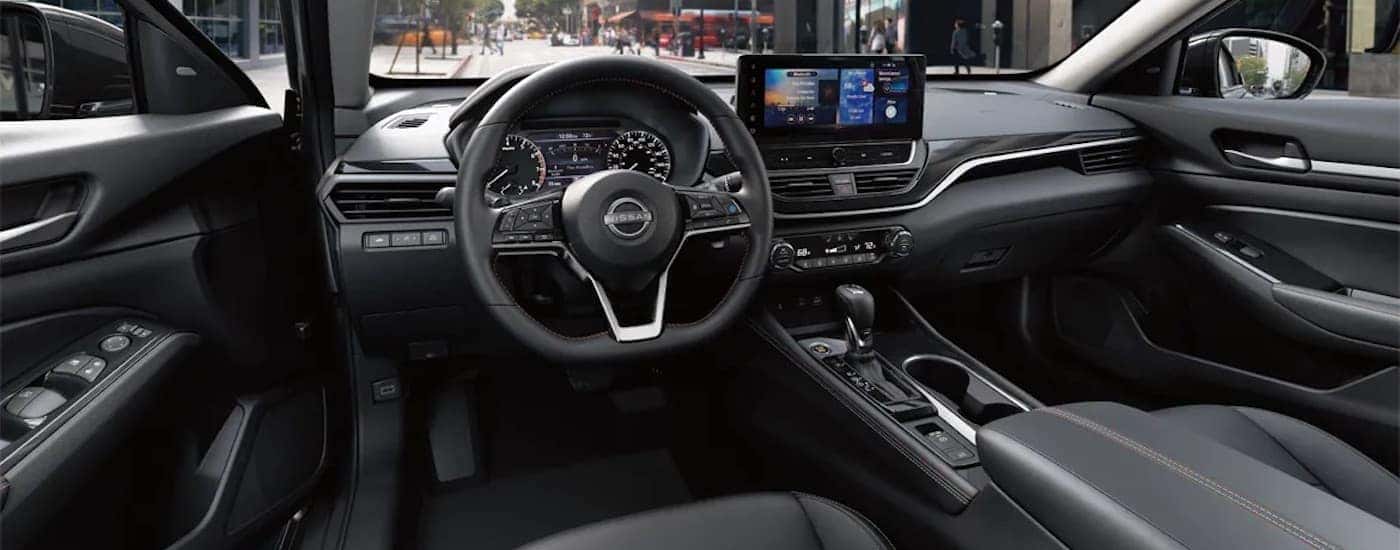 The black 2024 Nissan Altima is shown from the driver's seat.
