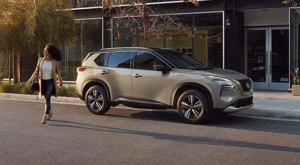 A silver 2024 Nissan Rogue SL is shown parked near a city curb.