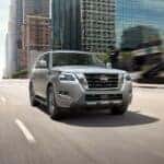 A silver 2024 Nissan Armada Platinum is shown driving on a city street.