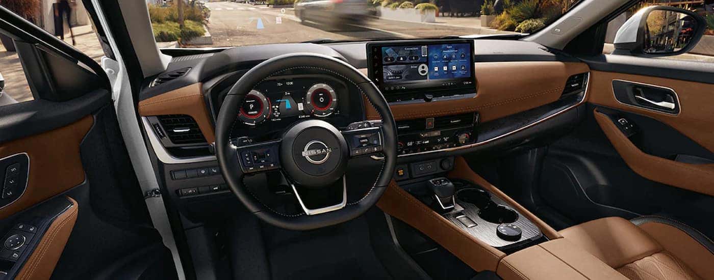 The brown leather interior and digital displays in a 2024 Nissan Rogue Platinum.