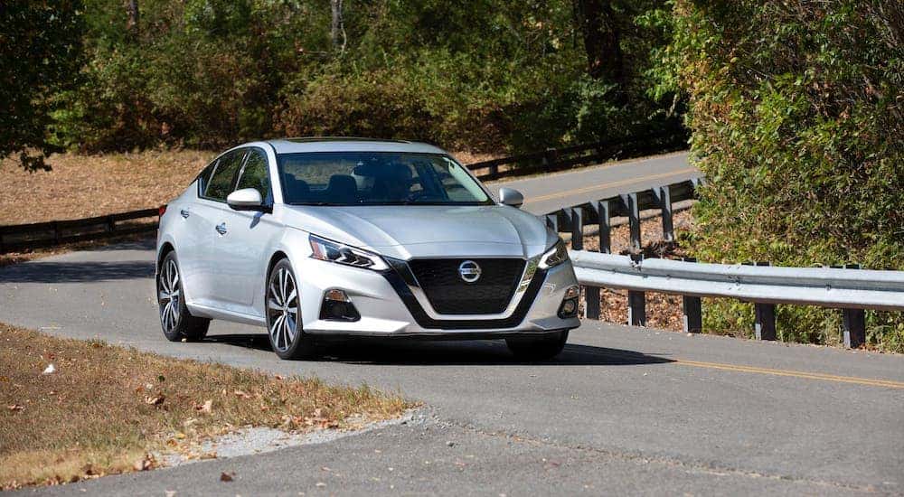 A silver 2021 Nissan Altima is shown driving on a highway.