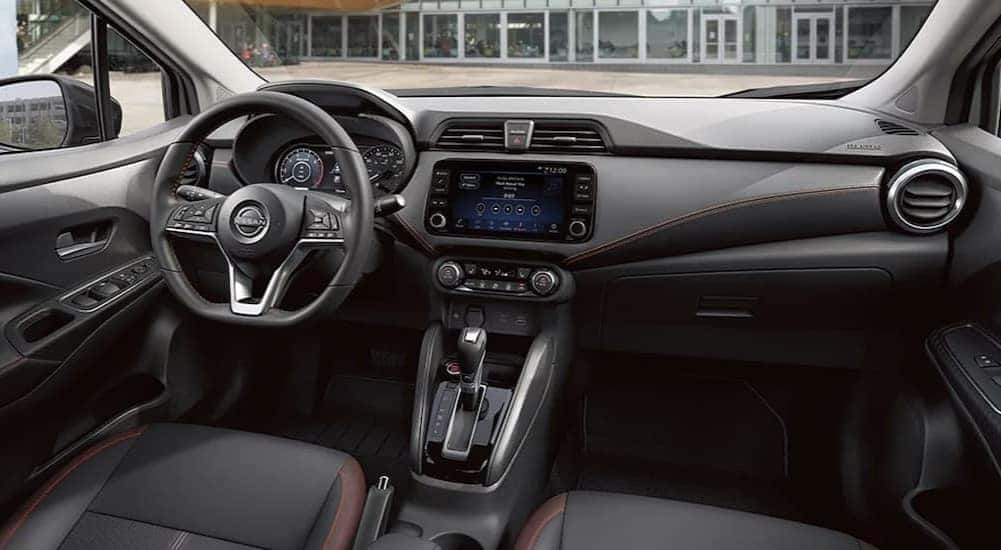 The black interior and dash in a 2024 Nissan Versa for sale is shown.