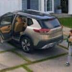 A tan 2024 Nissan Rogue Platinum is shown parked on a driveway.
