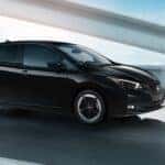 A black 2025 Nissan Leaf SV Plus is shown driving on a bridge.