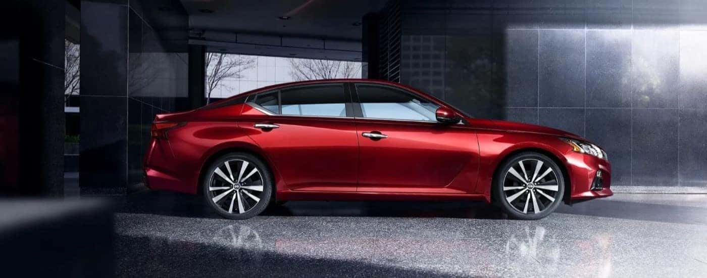 Side angle view of a red 2019 Nissan Altima parked in a building.