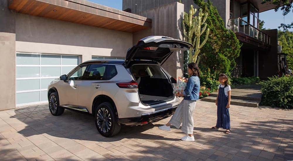 A silver 2024 Nissan Rogue is shown from the rear at an angle.