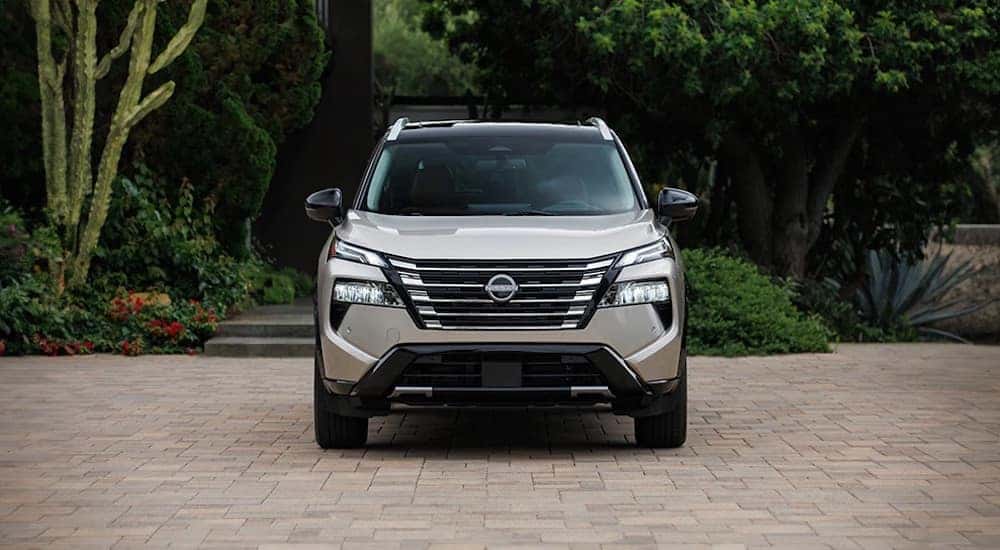 A tan 2025 Nissan Rogue is shown from the front.