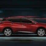 A red 2024 Nissan Murano Platinum is shown driving fast.