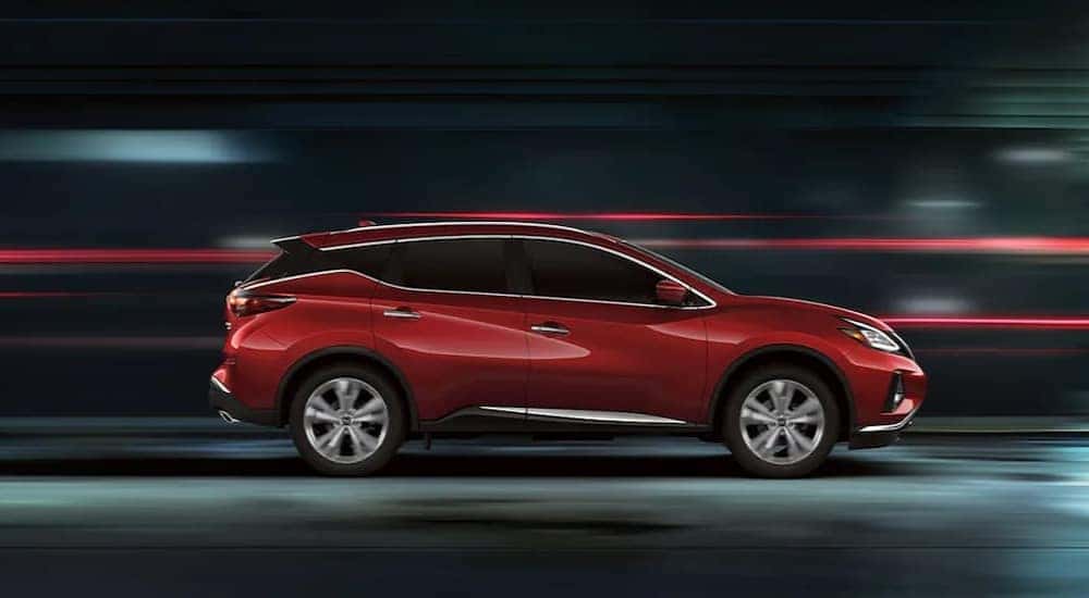 A red 2024 Nissan Murano Platinum is shown driving fast.