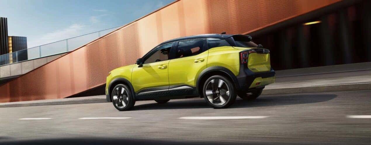 A yellow 2025 Nissan Kicks SR is shown driving on a street.