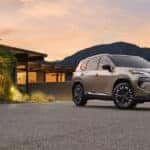 A silver 2025 Nissan Rogue Platinum parked in front of a house at dusk.