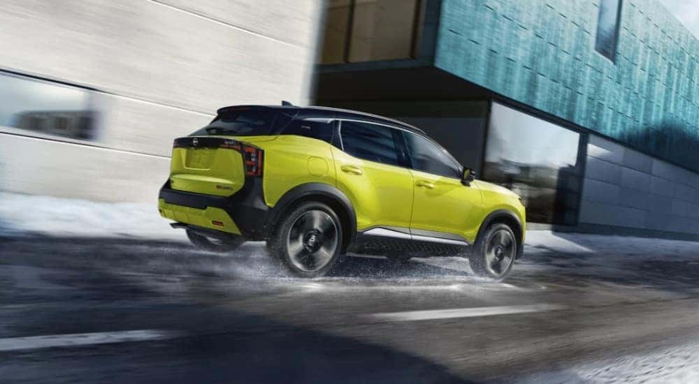 A green 2025 Nissan Kicks SR is shown driving through snow.