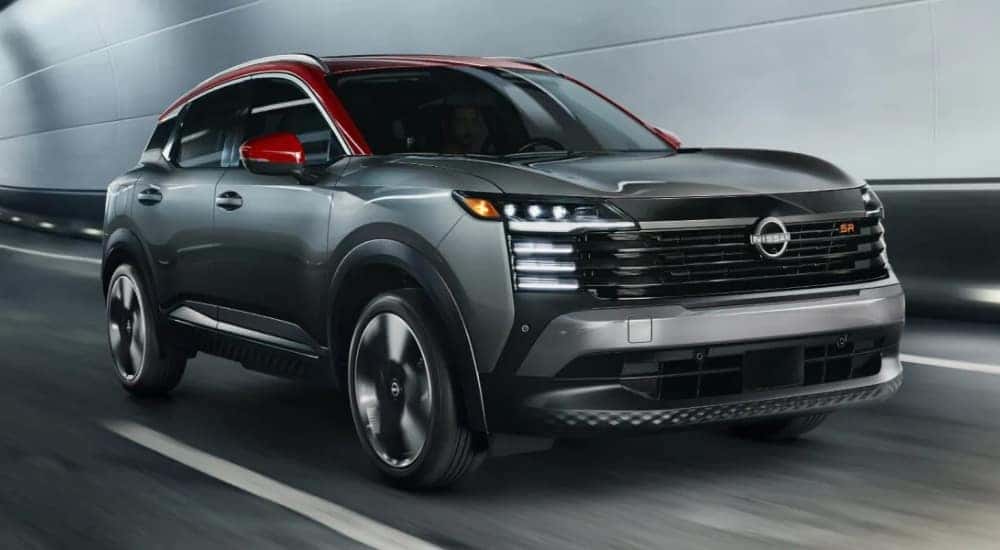 A grey 2025 Nissan Kicks SR is shown from the front at an angle during a 2025 Nissan Kicks vs 2025 Chevy Trax comparison.