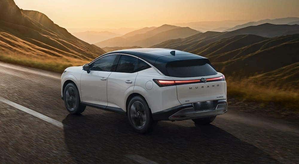 A white 2025 Nissan Murano Platinum is driving on an open highway.