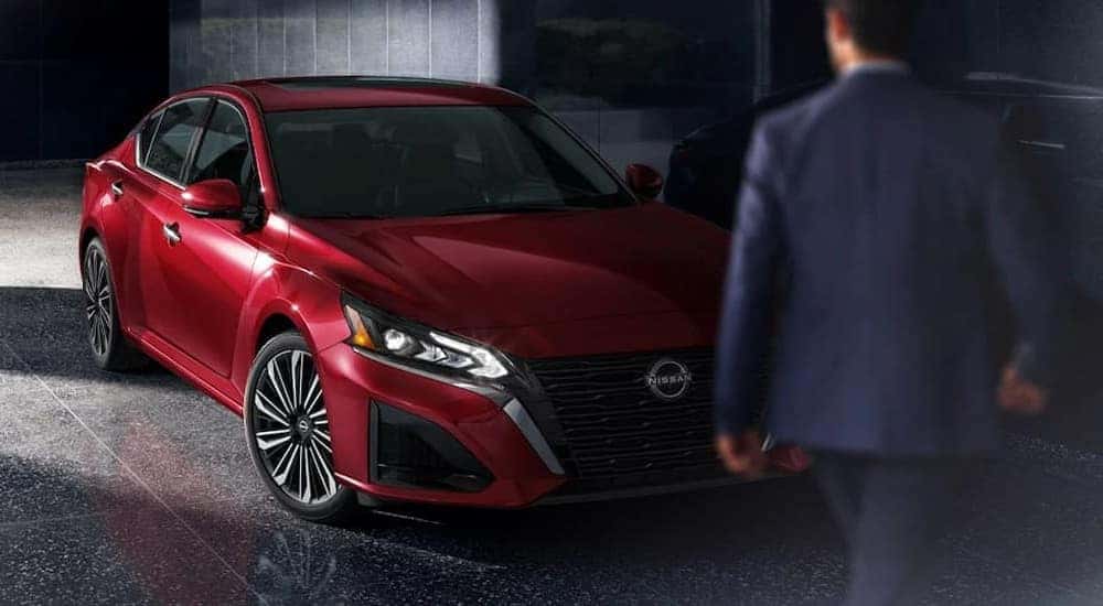 A red 2025 Nissan Altima SL is shown parked on a showroom floor.