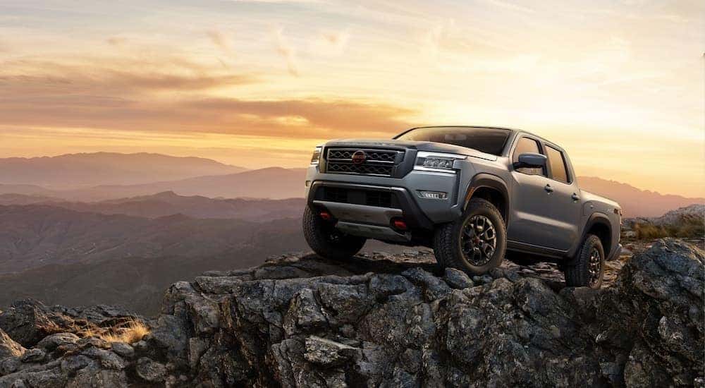A grey 2025 Nissan Frontier is shown from the front.