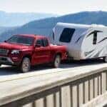 A red 2025 Nissan Frontier is shown from the front at an angle.