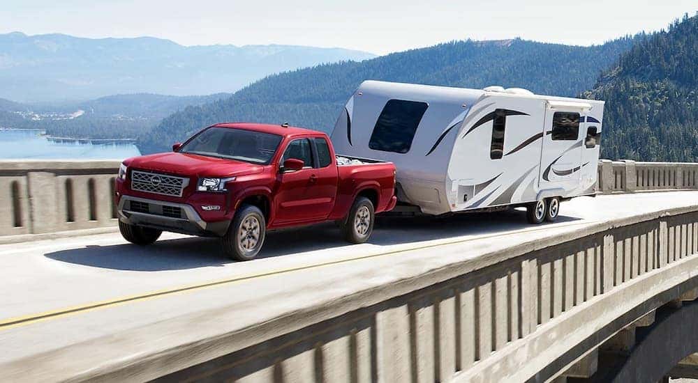 A red 2025 Nissan Frontier is shown from the front at an angle.