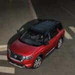 High angle view of a red 2025 Nissan Pathfinder turning around a curb.