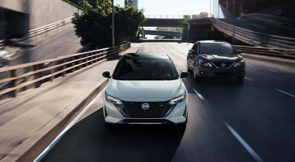 A white and black 2025 Nissan Sentra SR are shown driving on a highway.