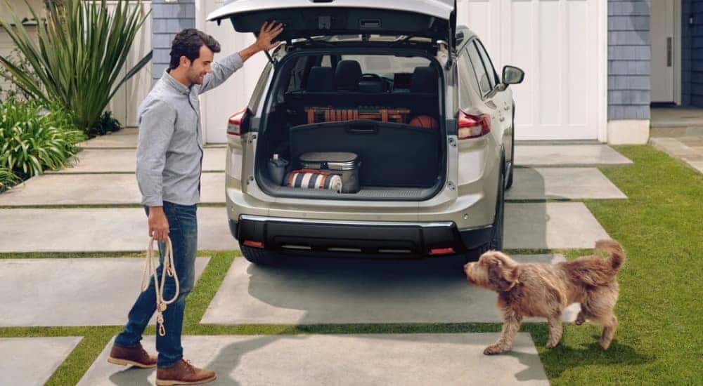 The open cargo area of a silver 2025 Nissan Rogue Platinum parked in a driveway.