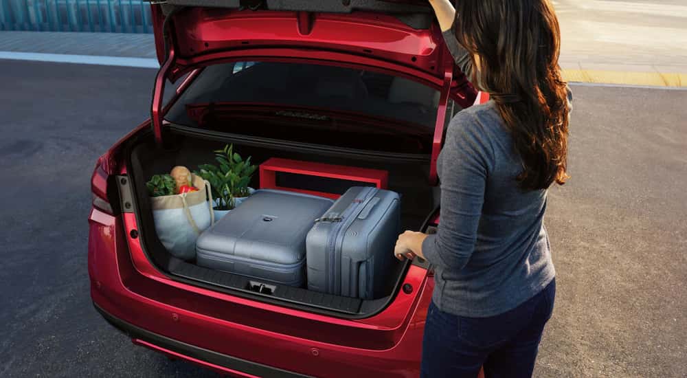 High rear angle view of the open hatchback of a red 2025 Nissan Versa.