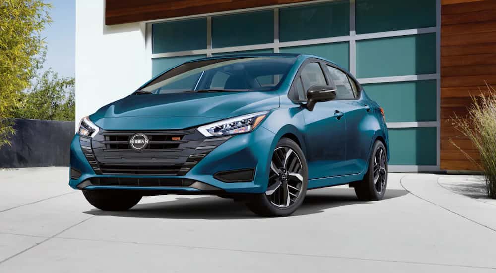 A blue 2025 Nissan Versa SR parked on a driveway and angled left.