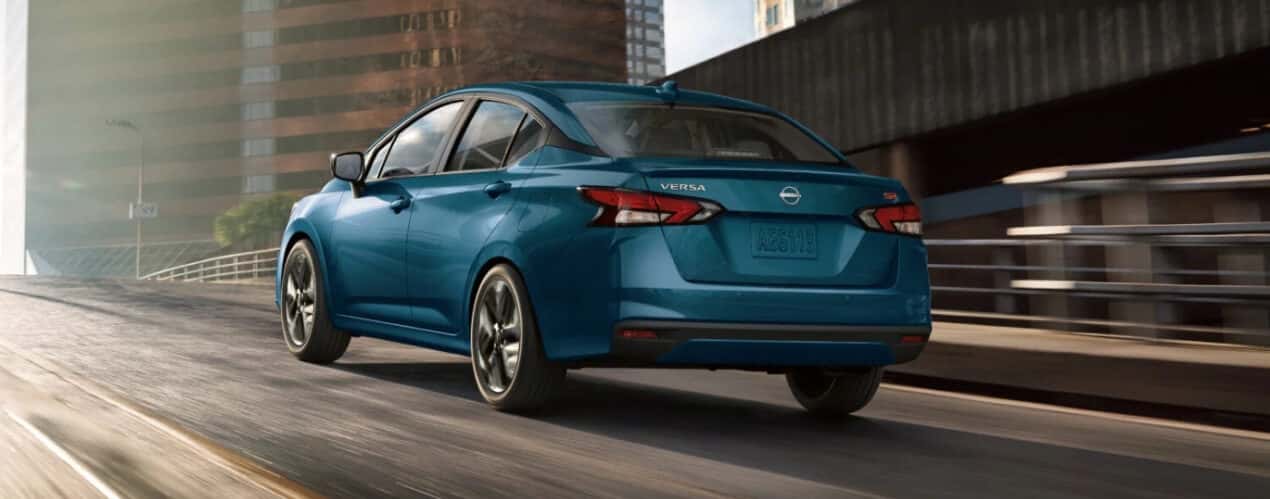 A teal 2025 Nissan Versa SR is shown driving up a ramp.