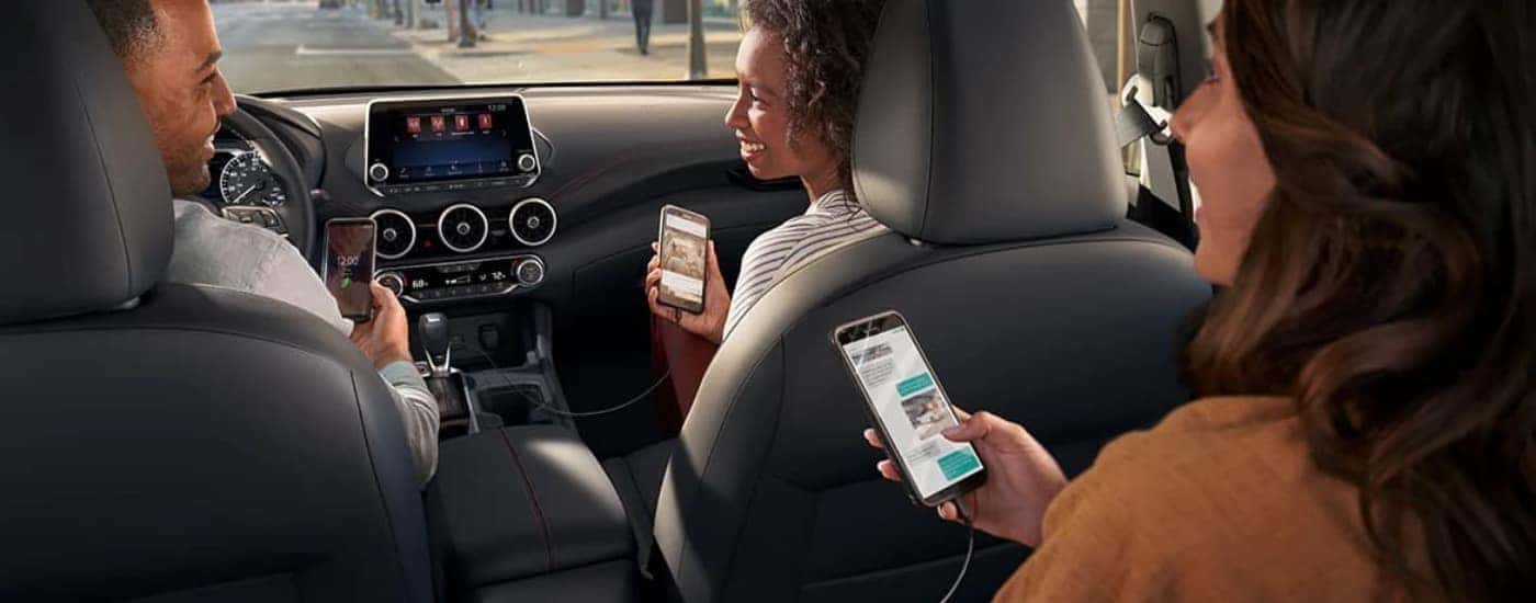People are shown using smartphones in a 2024 Nissan Sentra.