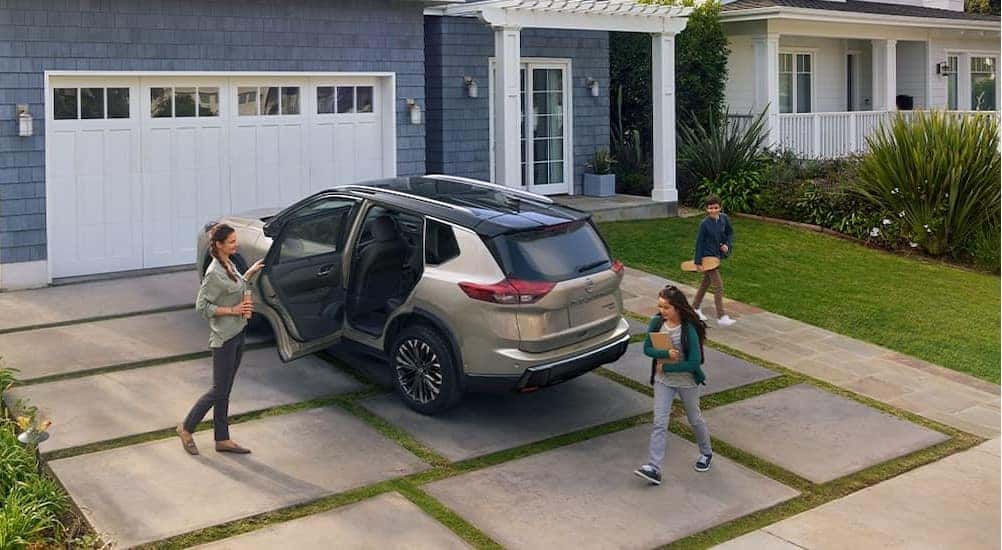 A tan 2025 Nissan Rogue parked on a driveway.