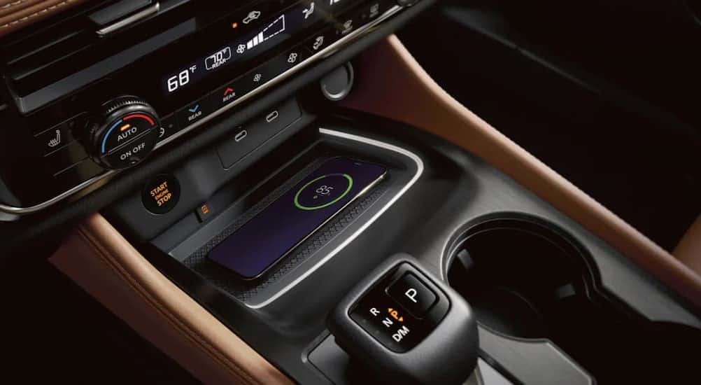 A phone charging in the center console of a 2025 Nissan Rogue.