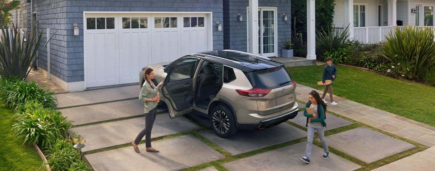 A bronze 2025 Nissan Rogue in a driveway.
