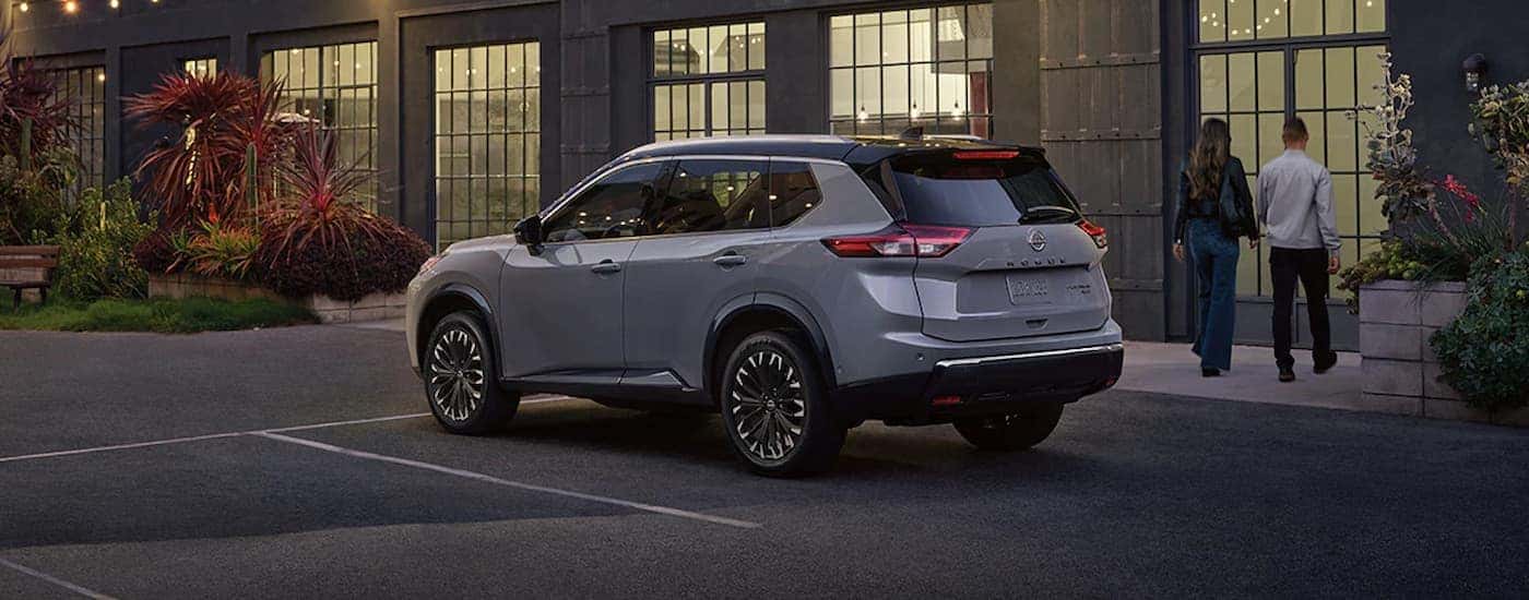 Grey 2025 Nissan Rogue parked outside of a restaurant.