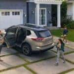 A bronze 2025 Nissan Rogue in a driveway.