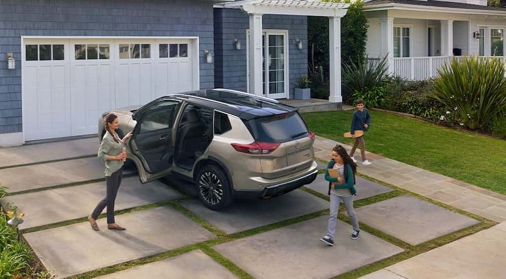 A bronze 2025 Nissan Rogue in a driveway.