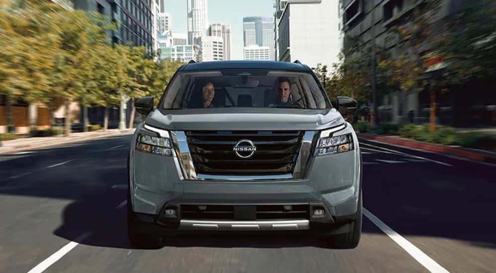 A gray 2025 Nissan Pathfiner Platinum driving in a city.