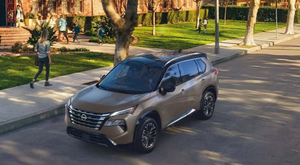 A tan 2025 Nissan Rogue parked near a school.