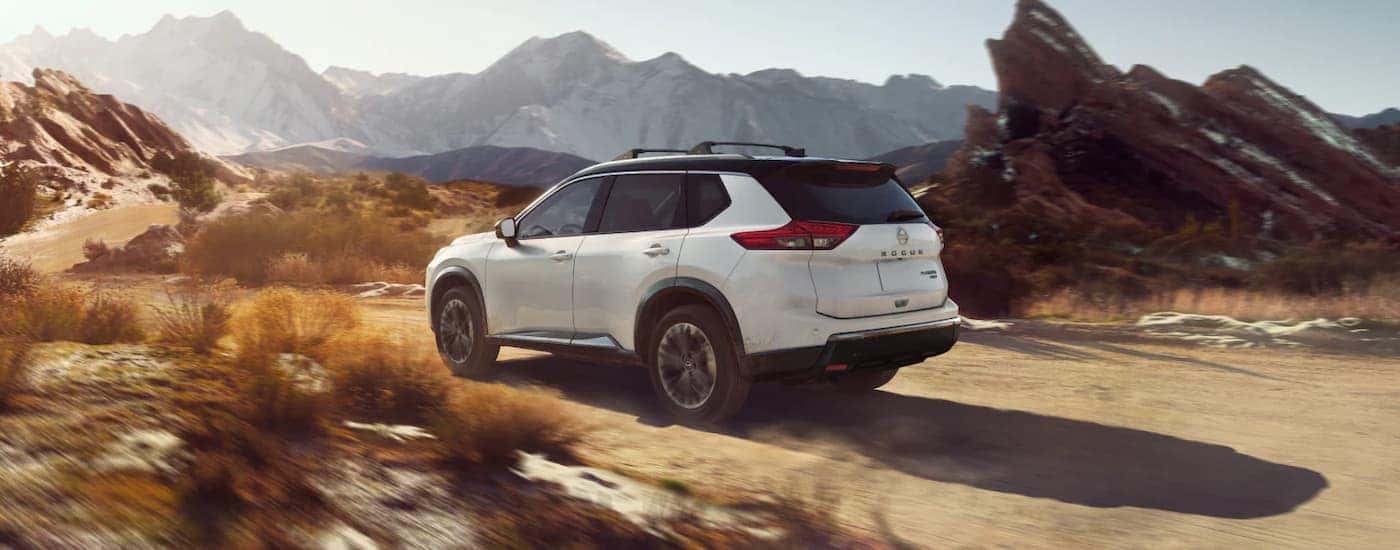 A white 2025 Nissan Rogue off-roading on sand