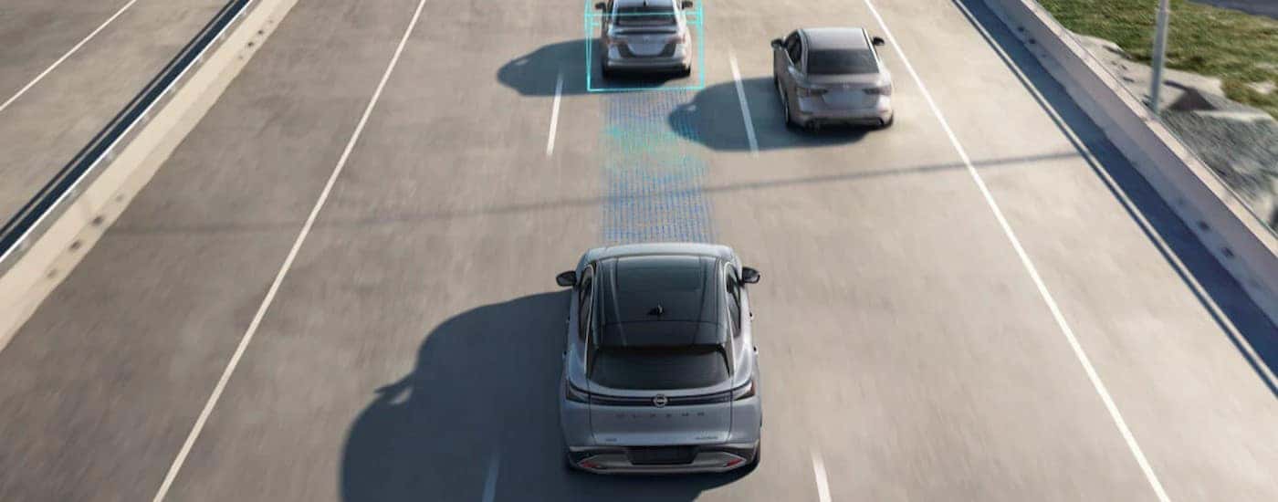 two gray 2025 Nissan Muranos displaying simulated safety lines on a highway.