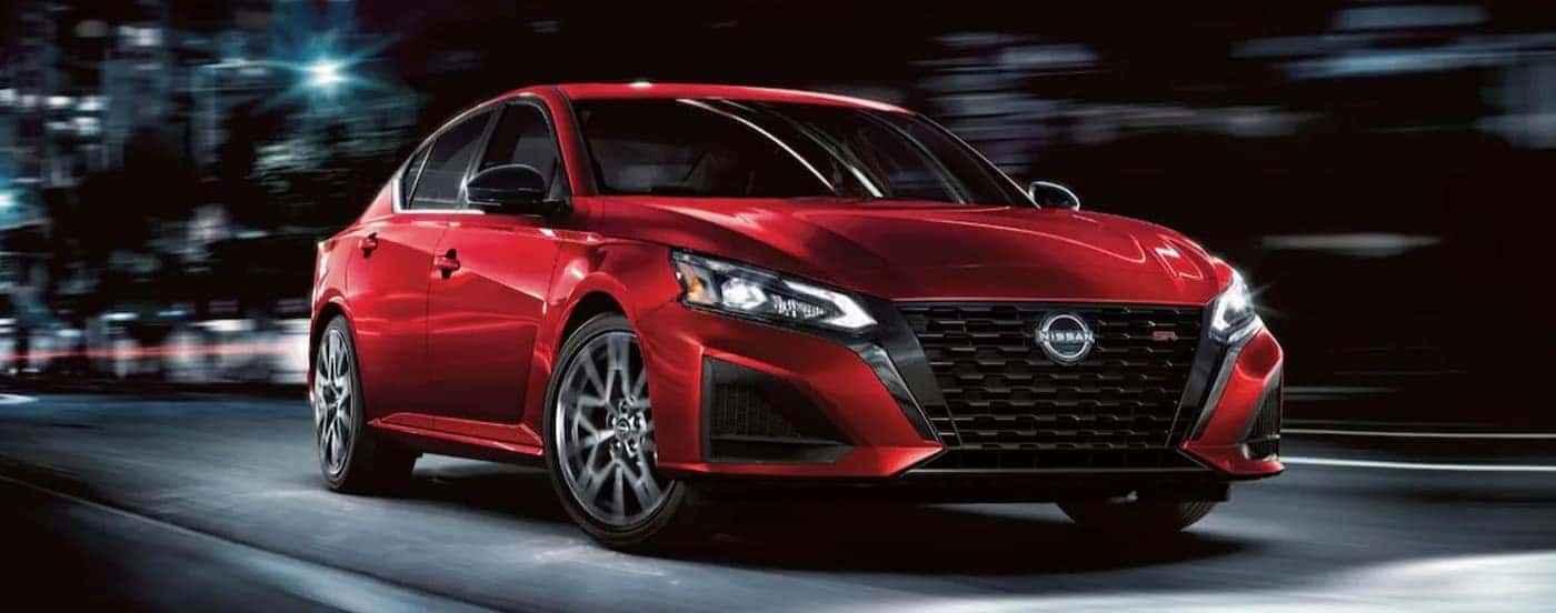 A red 2024 Nissan Altima SR driving in a city.